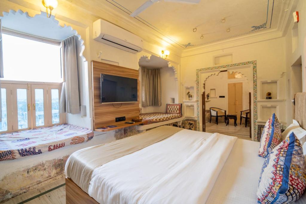 ein großes Schlafzimmer mit einem großen Bett und einem Spiegel in der Unterkunft Amoraya Udaipur in Udaipur