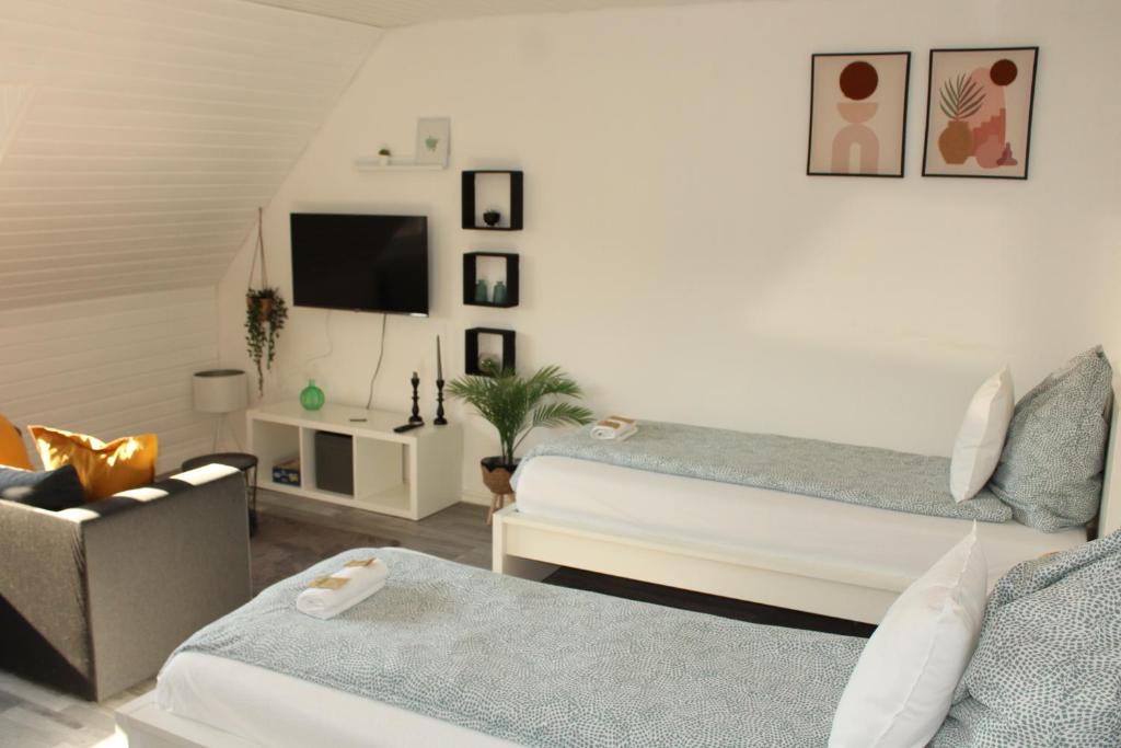 een woonkamer met twee bedden en een tv bij Wohlfühl & Schickes Apartment in Heilbronn