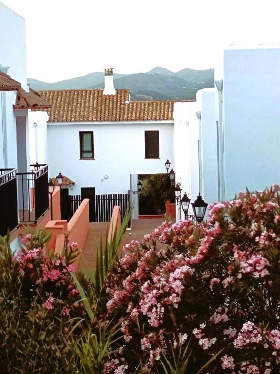 a white house with pink flowers in front of it at Beautiful Duplex with a Patio in Alcalá de los Gazules