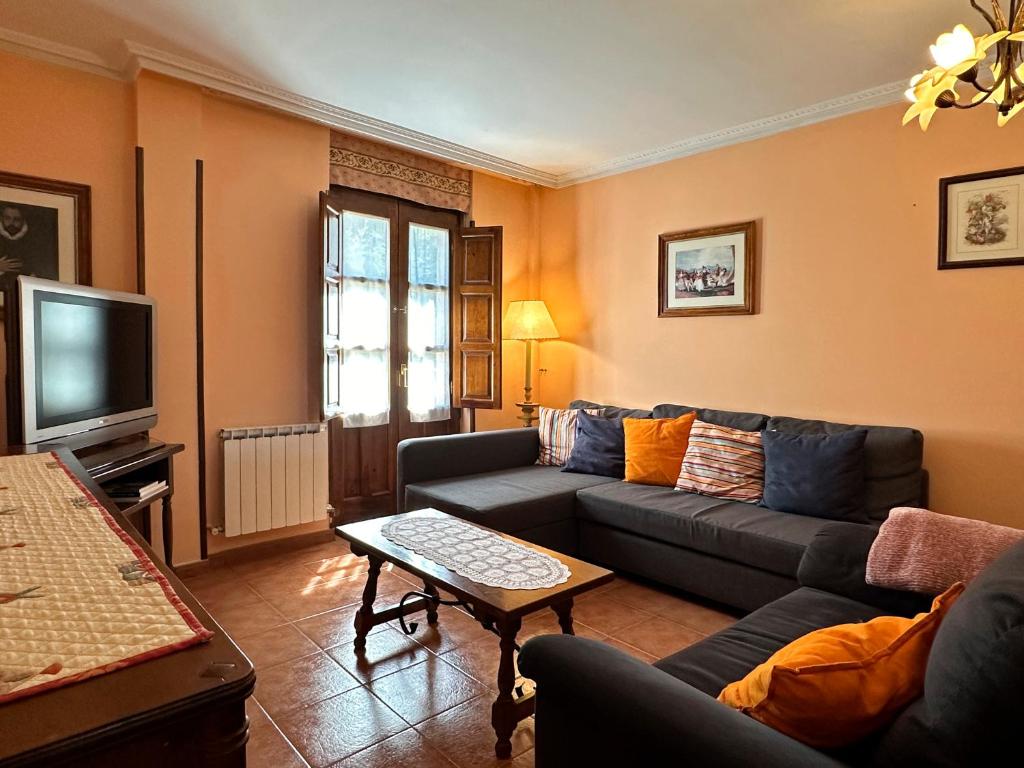a living room with a couch and a tv at Casa Rural Las Condesas in Santo Domingo de Silos