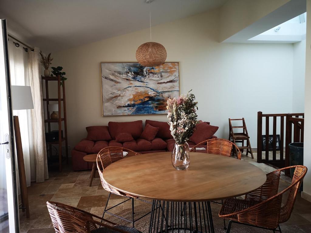 un salon avec une table avec des chaises et un canapé dans l'établissement Appartement duplex avec cour extérieure Avignon centre, à Avignon