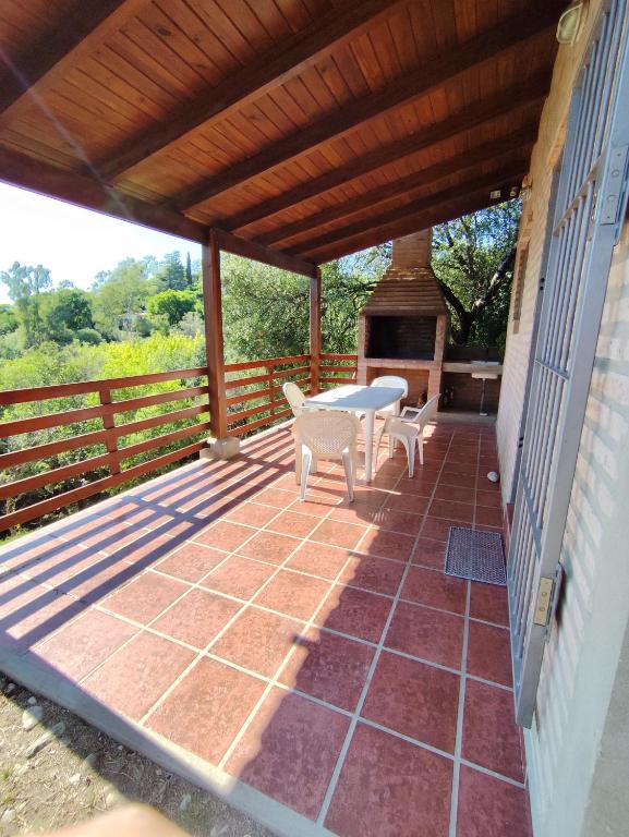a patio with a table and chairs and a grill at Cabañas Margus in La Granja