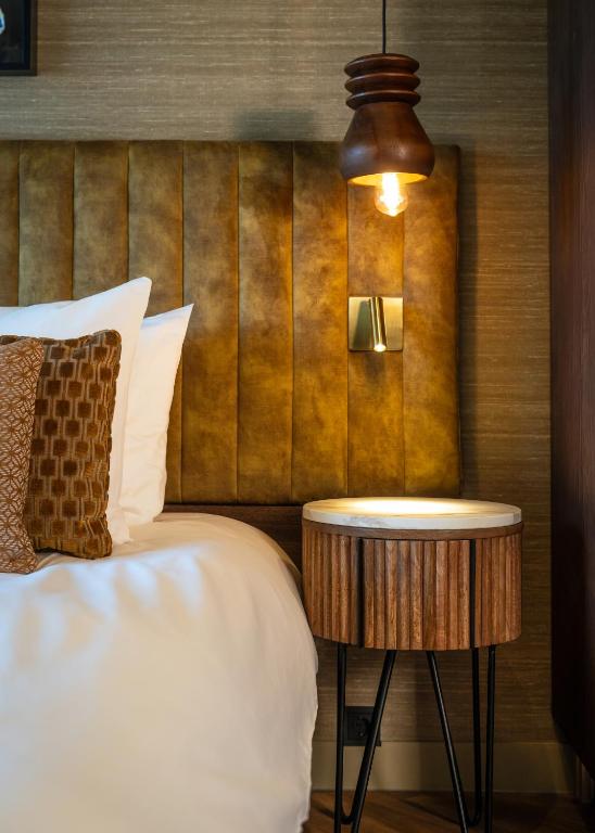 a bed with a side table next to a bed at Boutique Hotel De Smulpot in Den Burg