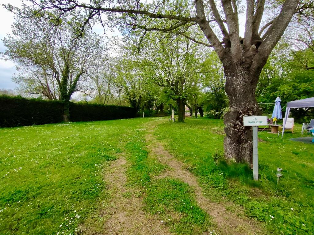 a dirt road next to a tree in a field at Camping Les Voiles Sur Grosne in Savigny-sur-Grosne