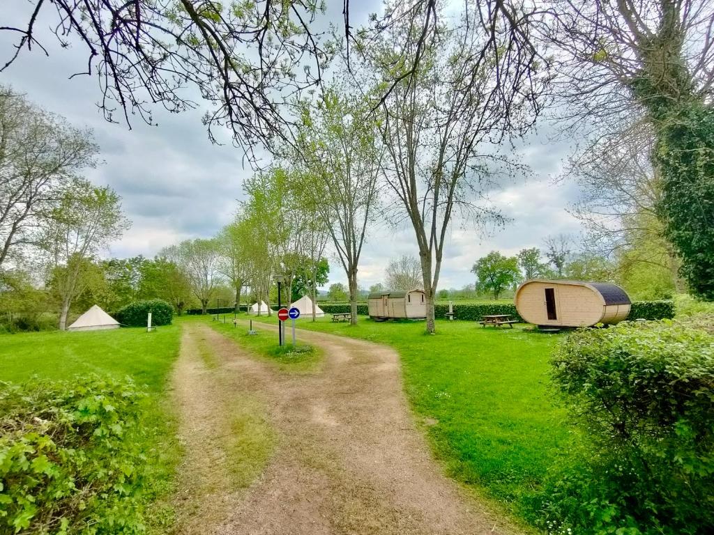 a dirt road through a field with tents at Camping Les Voiles Sur Grosne in Savigny-sur-Grosne