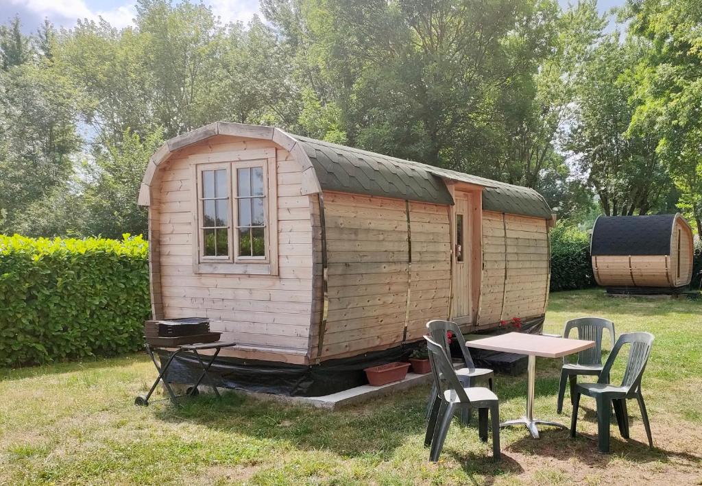 a small wooden house with a table and chairs at Camping Les Voiles Sur Grosne in Savigny-sur-Grosne