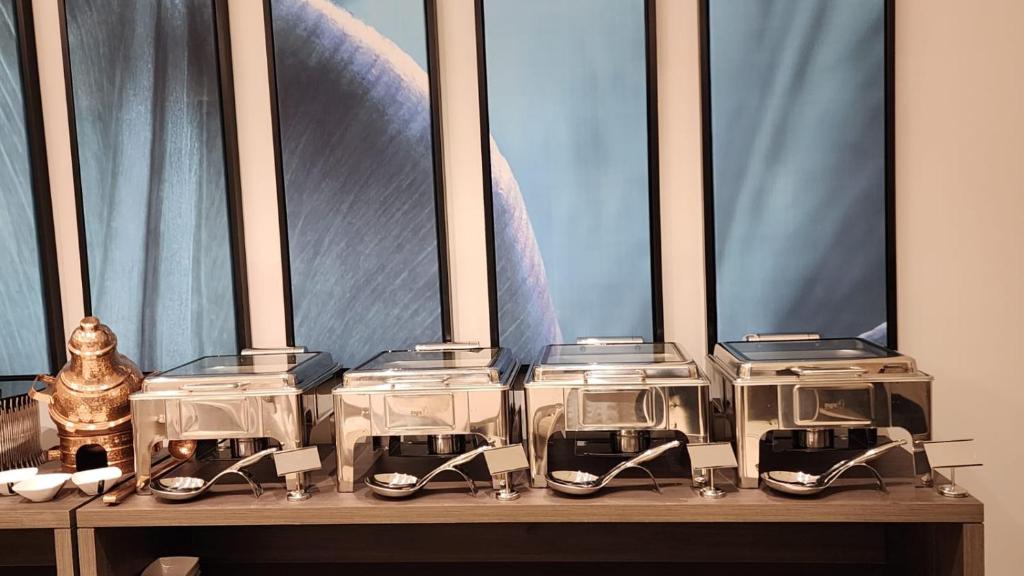 a group of four toasters on a table in front of windows at فندق ليورا Liora Hotel in Riyadh