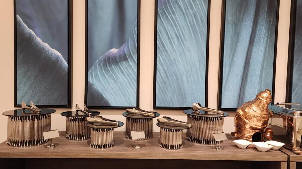 a table with five pots and a statue in front of windows at فندق ليورا Liora Hotel in Riyadh