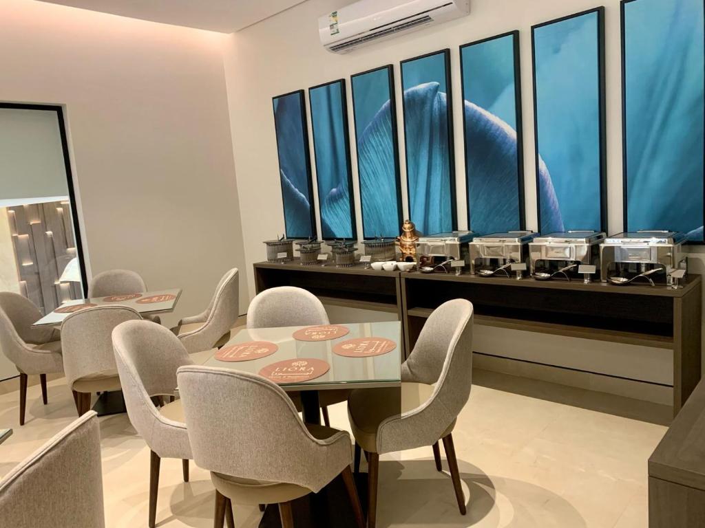 a dining room with a table and chairs and windows at فندق ليورا Liora Hotel in Riyadh