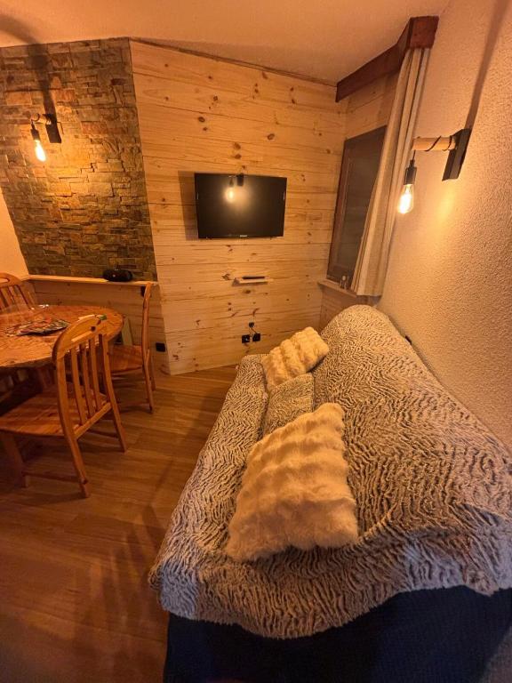 Cette chambre dispose d'un canapé, d'une table et d'une télévision. dans l'établissement Studio 4 personnes les Orres vue sur le lac, aux Orres