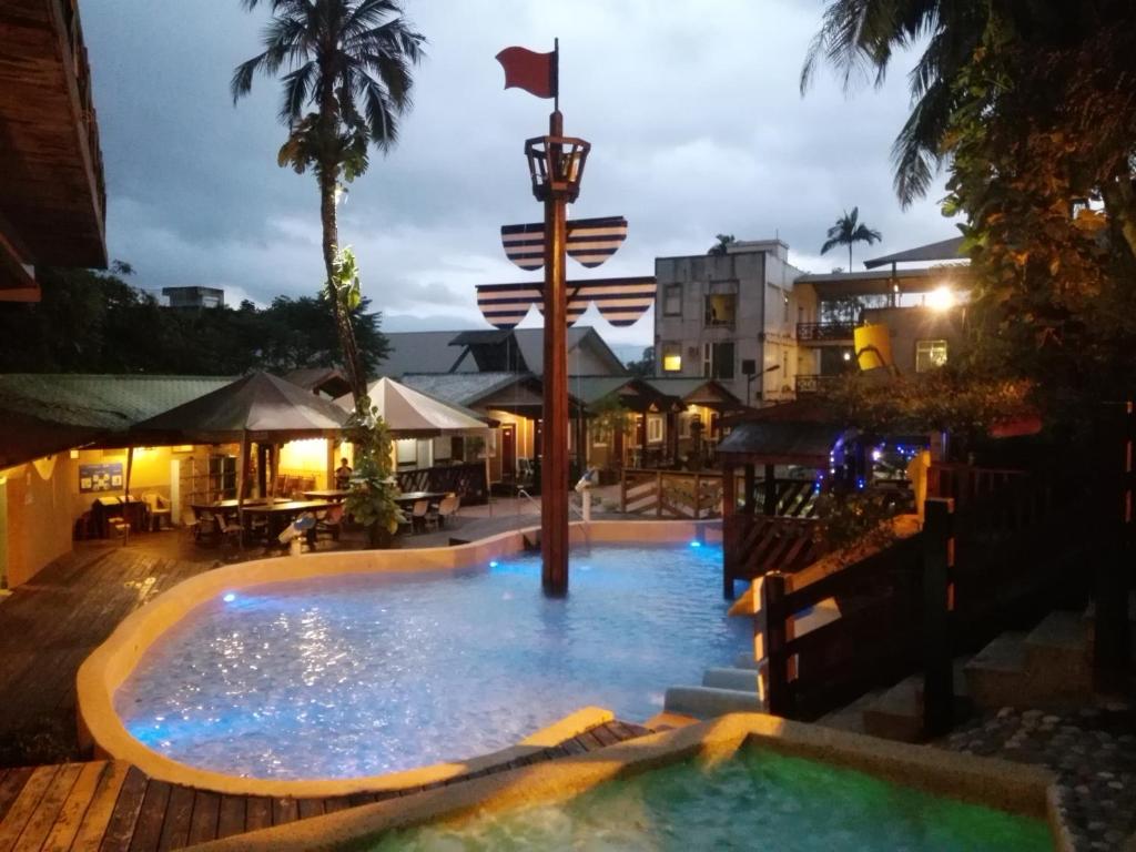 una piscina por la noche con una bandera en el medio en Cocos Hot Spring Hotel, en Ruisui