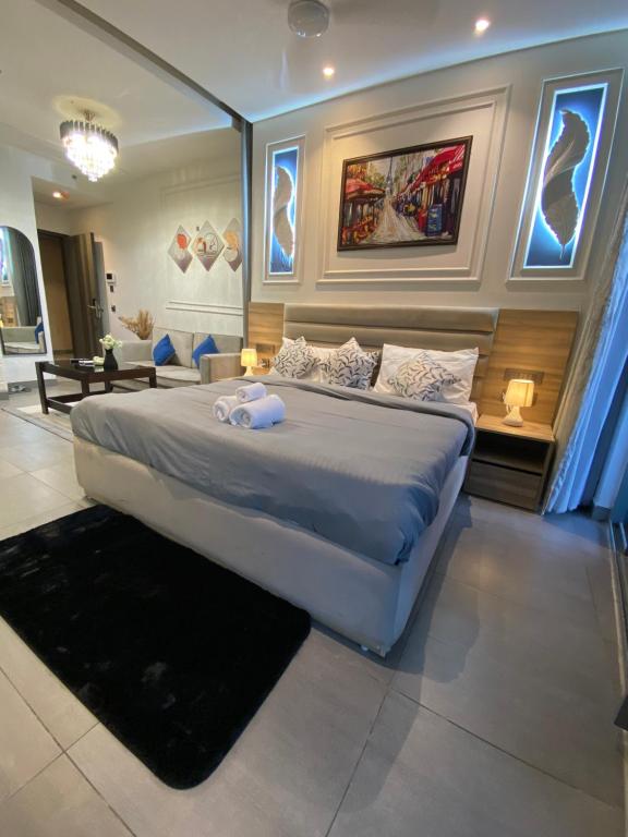 a bedroom with a large bed and a living room at Luxury Vello Stay Supernova in New Delhi