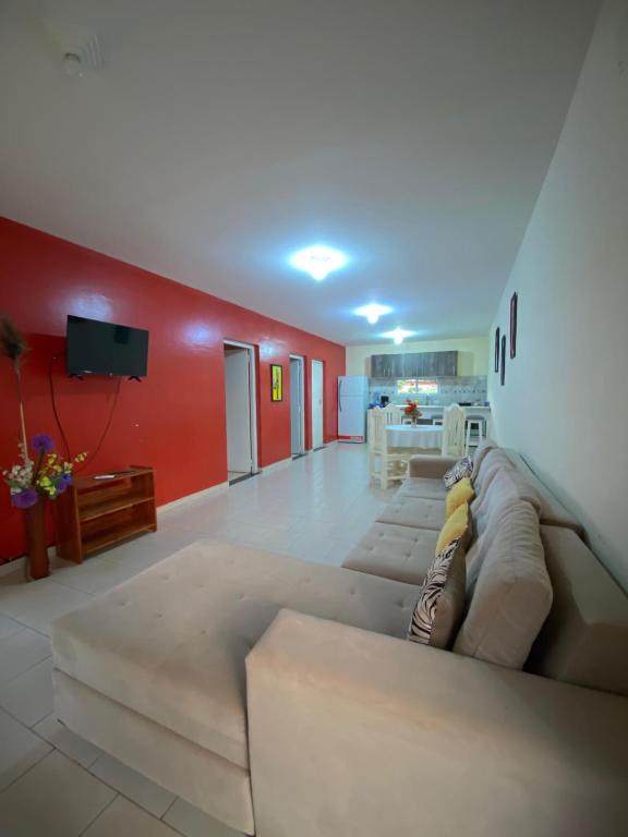 a living room with a couch and a red wall at departamento don Pedro 2 in Posadas