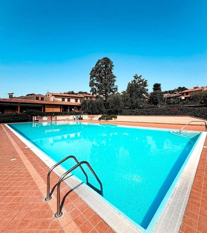a large blue swimming pool on a brick sidewalk at Lake Garda Hills in Ponti Sul Mincio