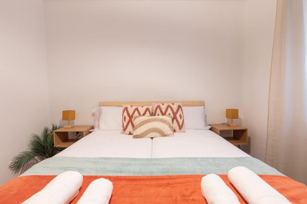 a bedroom with a white bed with two tables at Bilbao Urban Stay in Bilbao