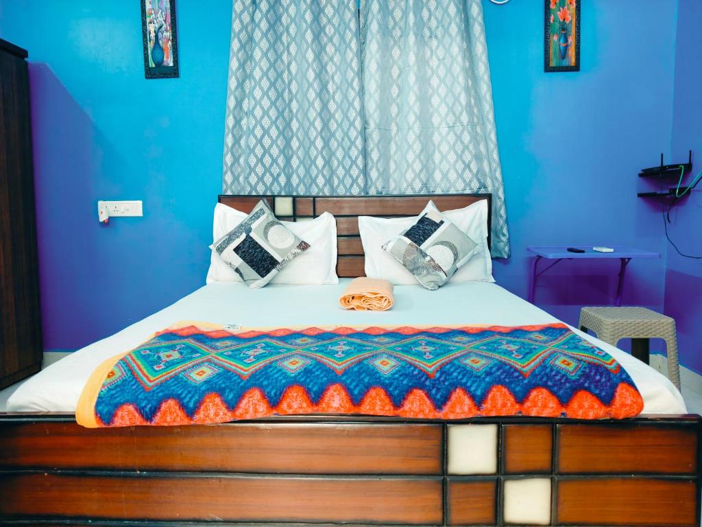 a bedroom with a bed with a blue wall at Studio Apartment with private entrance, behind DLF and near L&T, RMZ IT park and close to SRMC & MIOT Hospital in Chennai