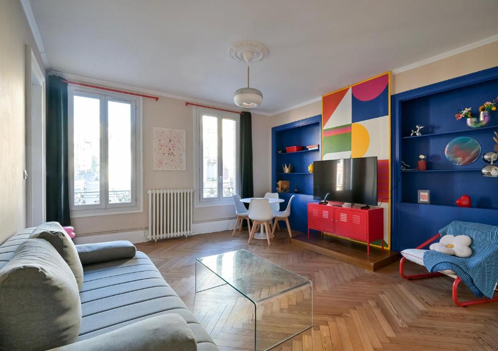 un salon avec un canapé et une télévision dans l'établissement La vie en couleurs, au Havre