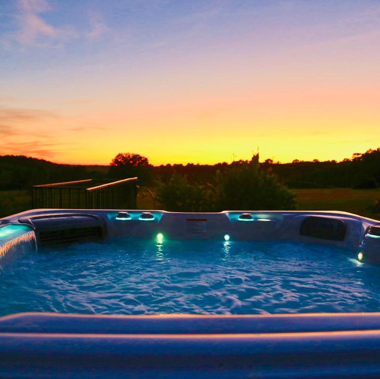 a hot tub with a sunset in the background at Gites Boutique in Villamblard