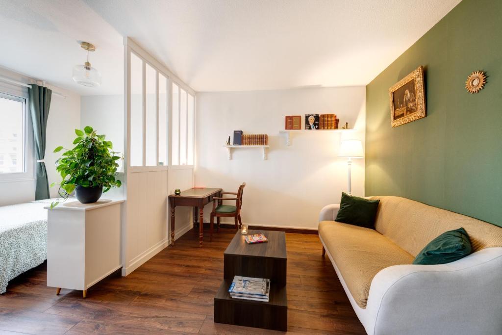 a living room with a couch and a table at Appartement proche du Parc de la Tête d'Or - Garage Gratuit in Villeurbanne