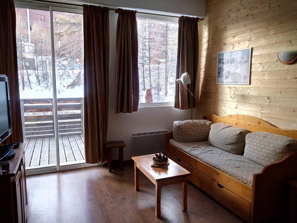 a living room with a couch in front of a window at Appartement confort Vars les Claux in Vars