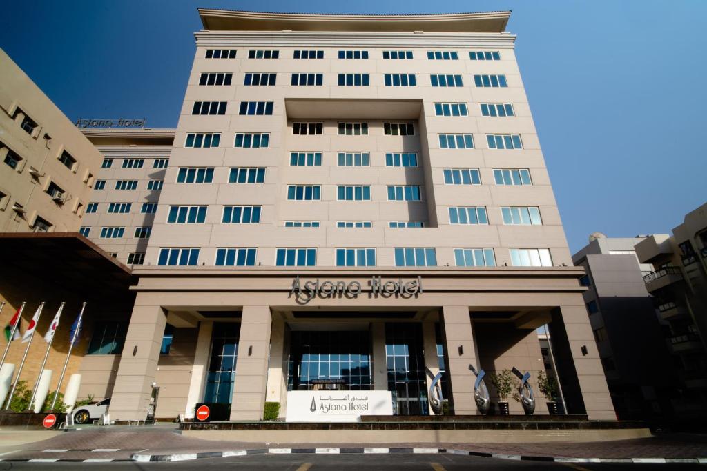 um grande edifício branco com uma placa nele em Asiana Hotel Dubai no Dubai