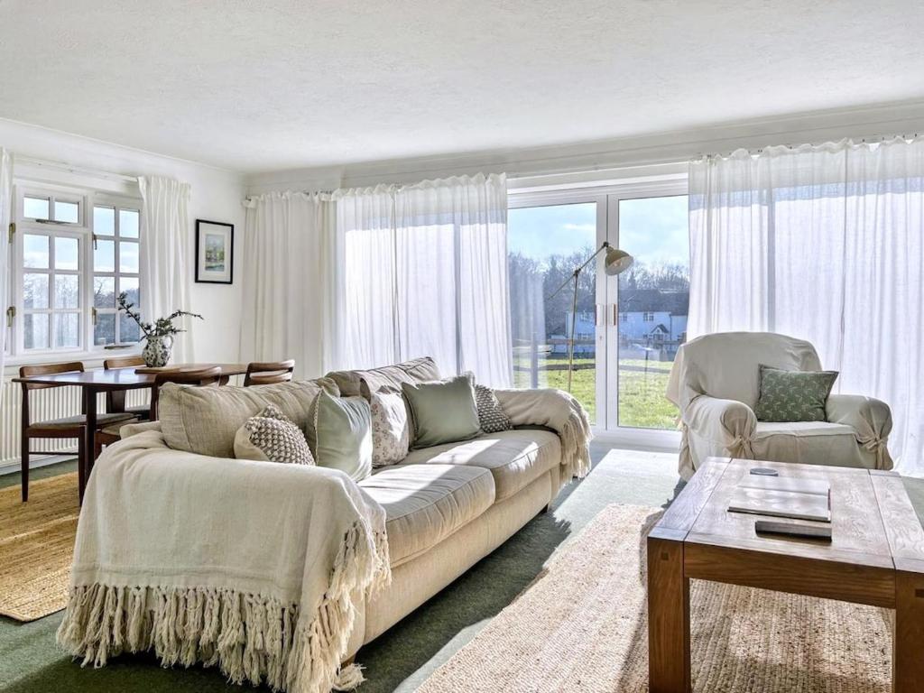 un salon avec un canapé et une table dans l'établissement Tranquil 2-Bed Nature Cottage with Free Parking, à Newick