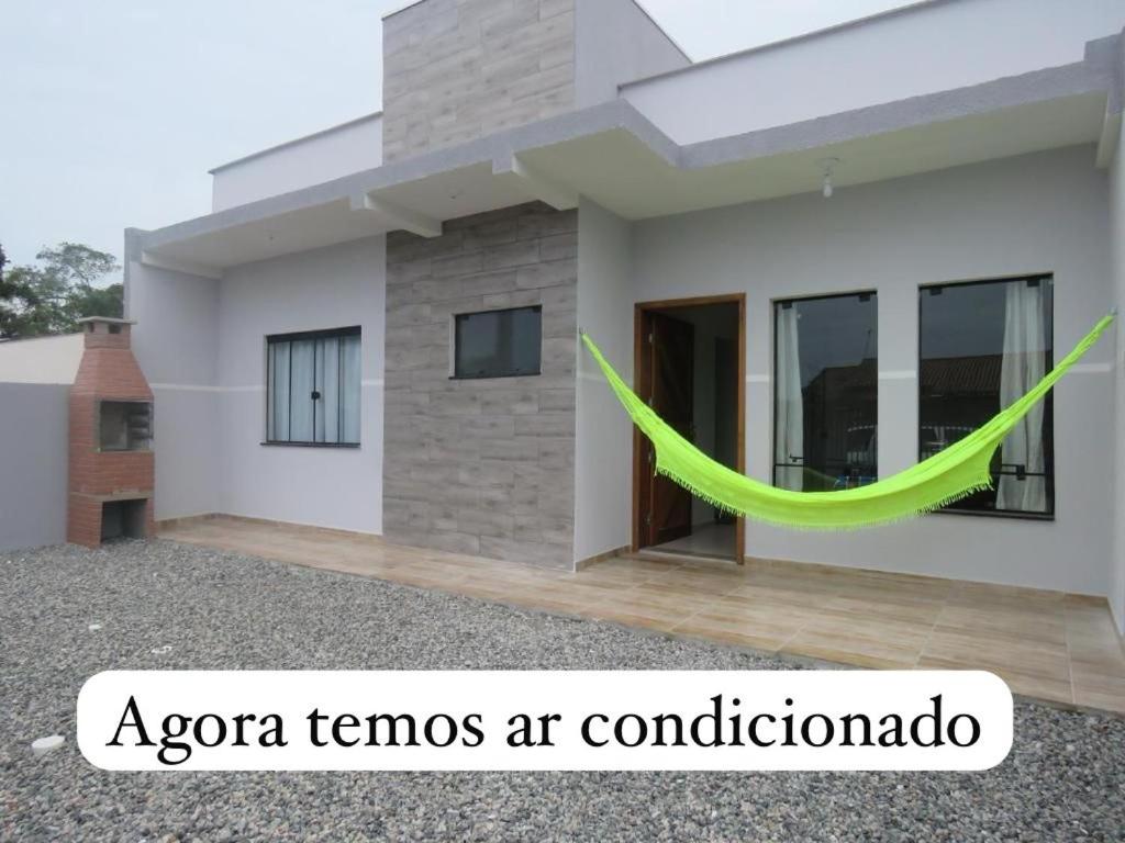 a house with a green ribbon in front of it at Casa do amor, vc pode ir andando até a praia in Itapoa
