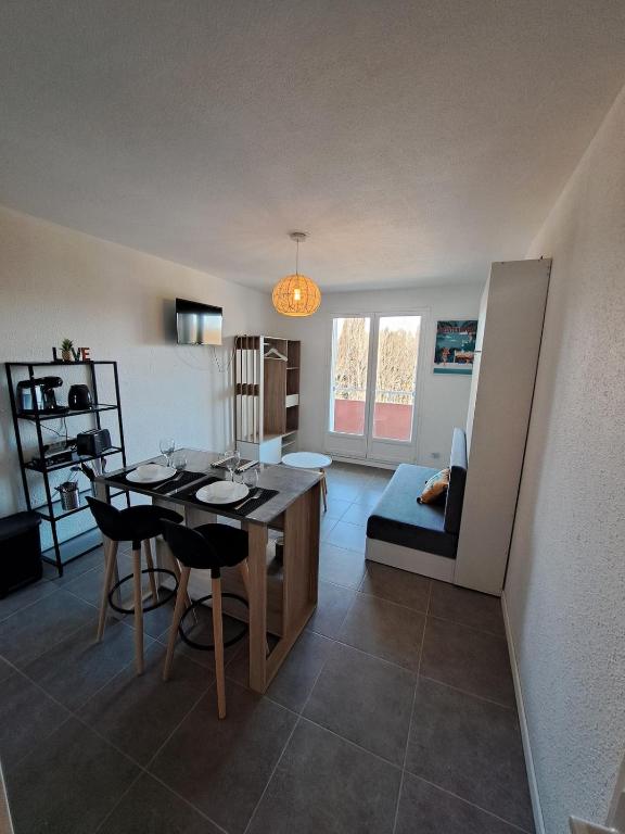 une cuisine et une salle à manger avec une table et des chaises dans l'établissement studio proche Narbonne centre, à Narbonne