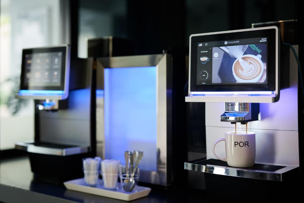 A self-service coffee station with automatic espresso machines and supplies.