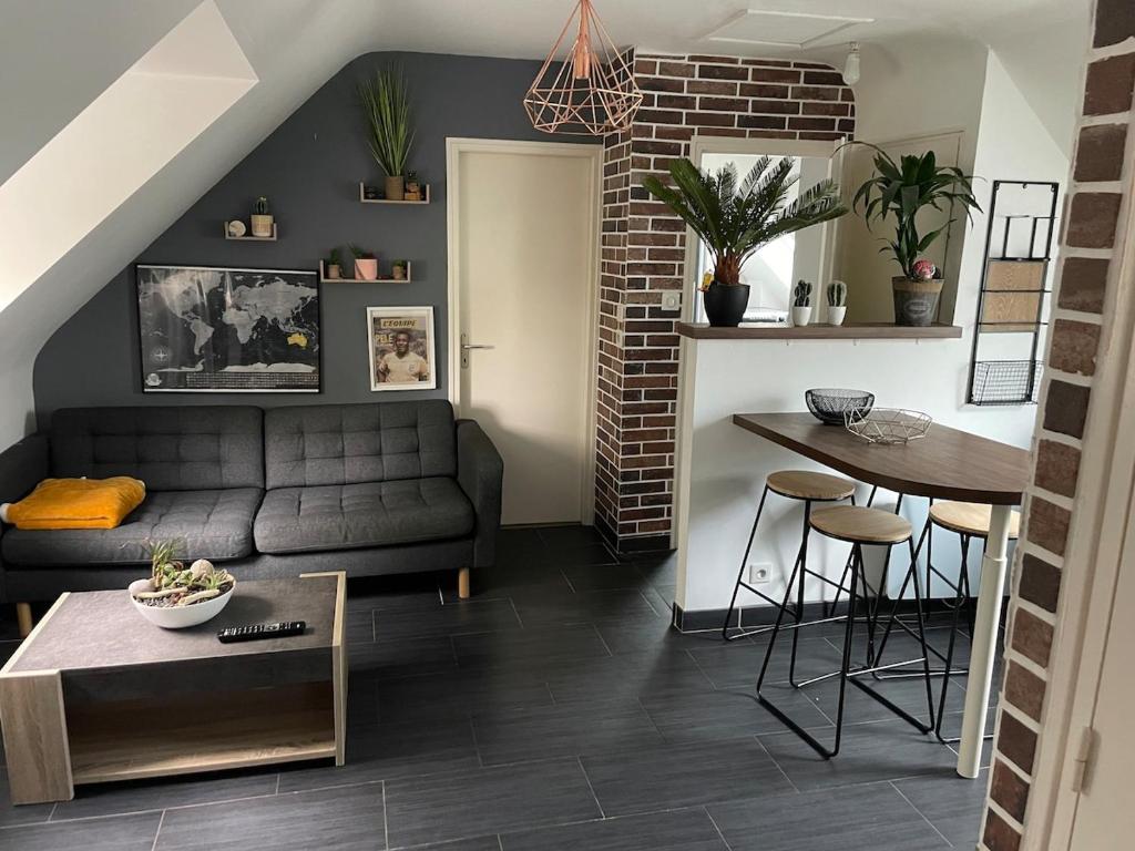 un salon avec un canapé et une table dans l'établissement Appartement, à Quimper