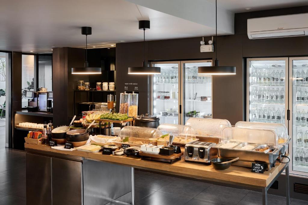 A self-service breakfast counter with hot dishes, cereals, fruit and refrigerated drinks.