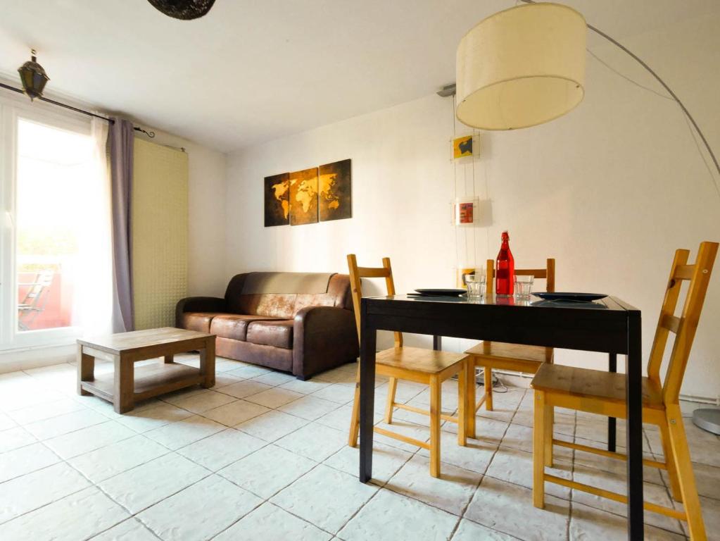 un salon avec une table, des chaises et un canapé dans l'établissement Le Camarguais - TERRASSE ET PARKING, à Montpellier