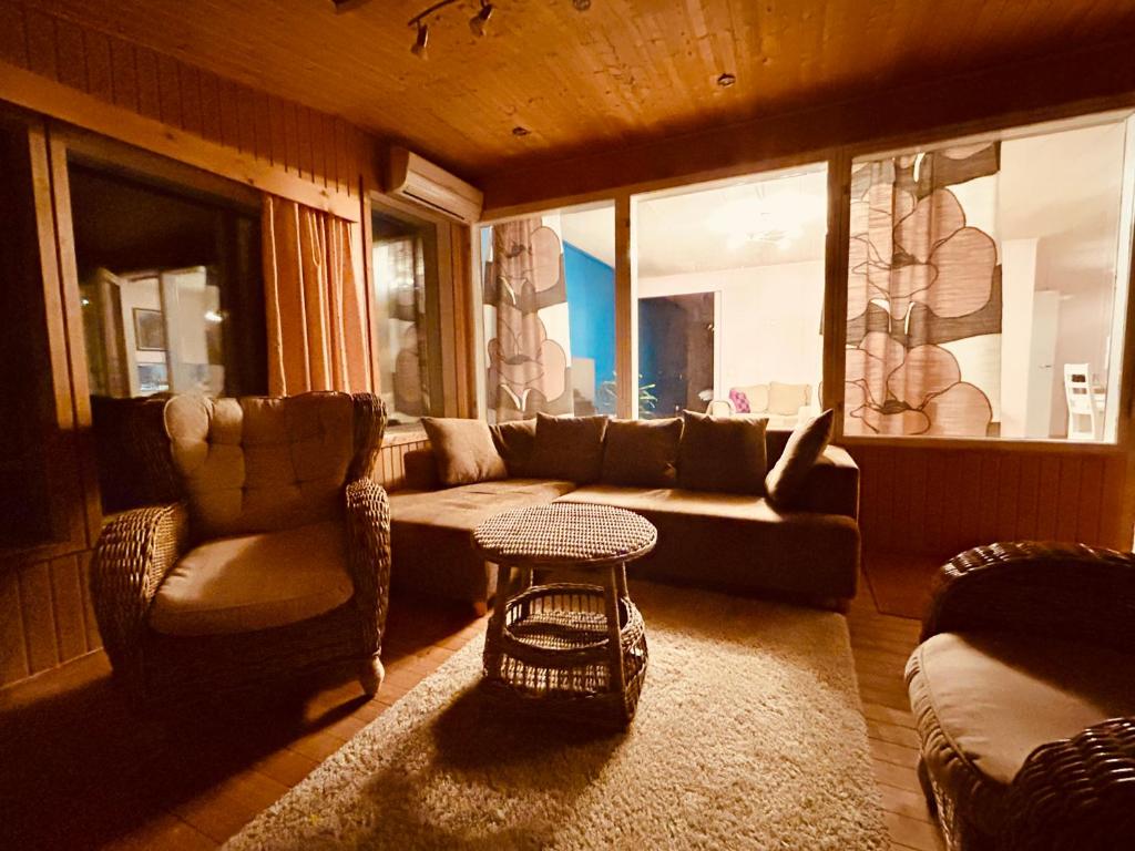 een woonkamer met een bank en een tafel bij Kaamos Old House in Rovaniemi