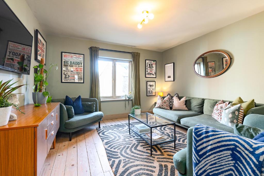 a living room with a couch and chairs and a mirror at Stylish Seaside home with King beds and parking in Scarborough