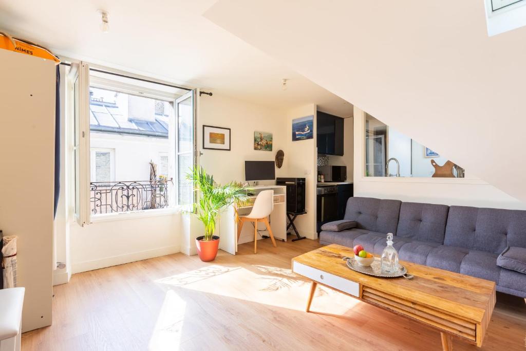 un salon avec un canapé et une table dans l'établissement Harmonie sous Elegance au Marais, à Paris