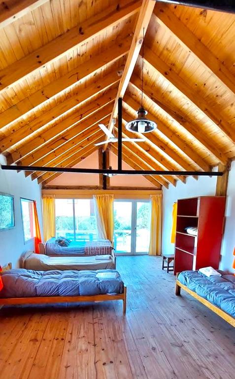 a large room with two beds and a wooden ceiling at Tres Piquillines in Puerto Madryn