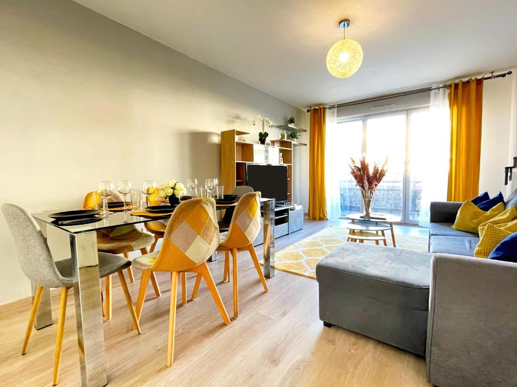 a dining room and living room with a table and chairs at Dream Saint-Georges à proximité de Disneyland in Bussy-Saint-Georges