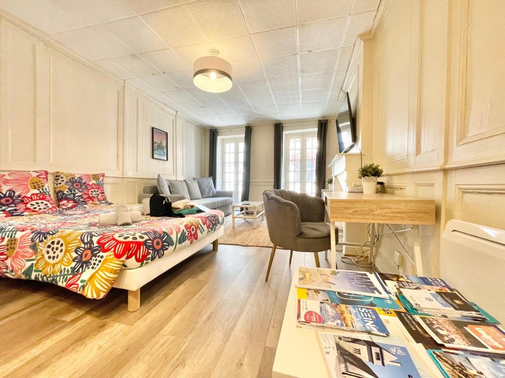 Cette chambre comprend un lit et une table avec des livres. dans l'établissement Le Kereon - Coeur du centre historique, rues pietonnes !, à Quimper