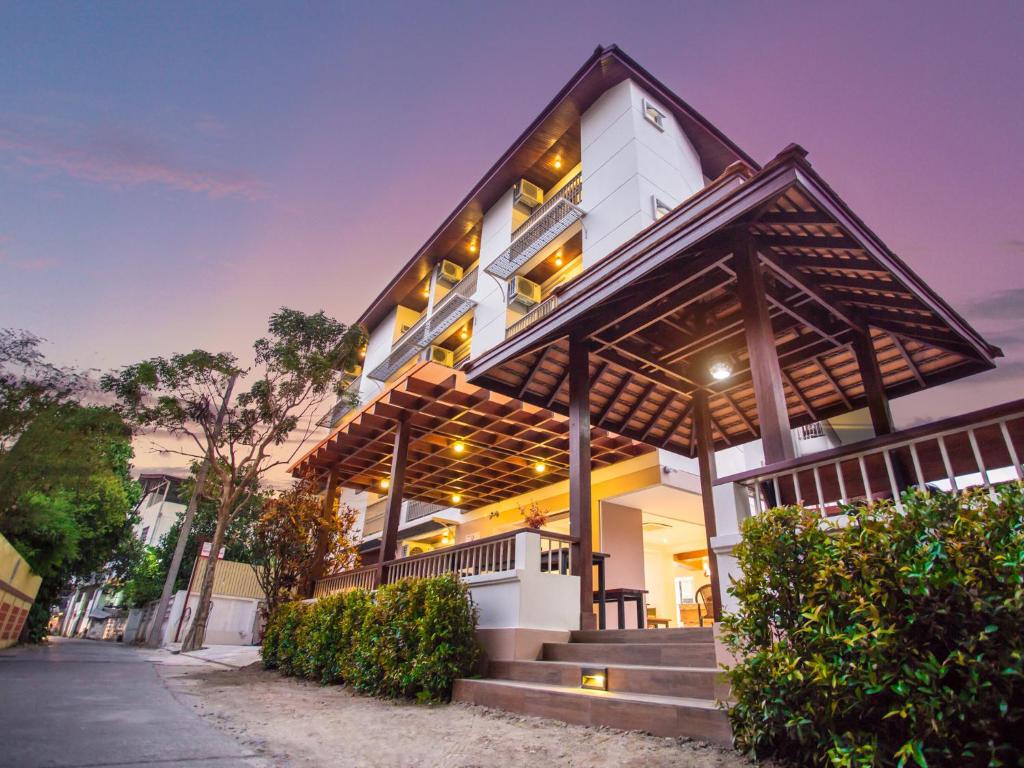 a white house with a wooden roof at Rendezvous Classic House in Chiang Mai