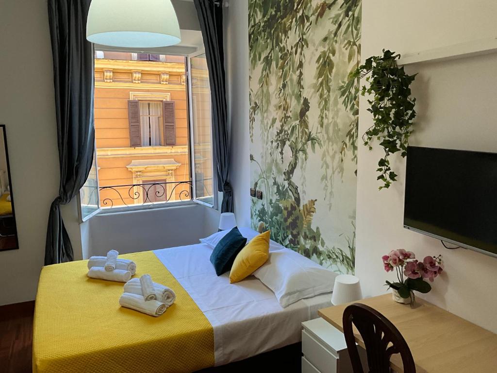 una camera da letto con un letto e una finestra con asciugamani di Maria House Saint Peter a Roma