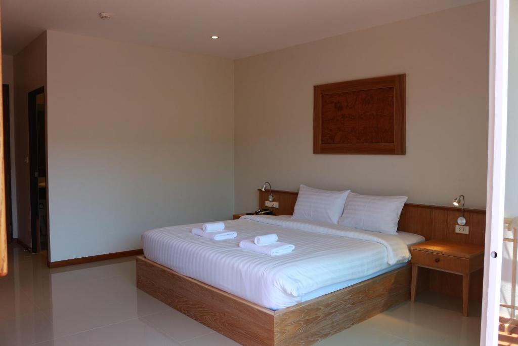 a bedroom with a bed with two towels on it at Crystal Lamai Hotel in Lamai