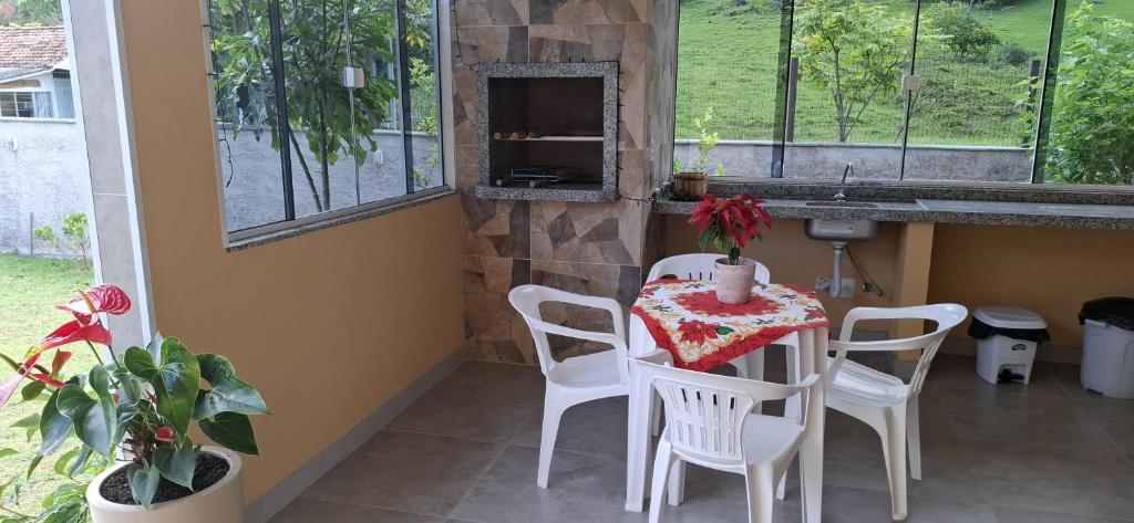 une table et des chaises dans une cuisine avec un évier dans l'établissement Casa da Naná - Praia da Gamboa - Garopaba, à Garopaba