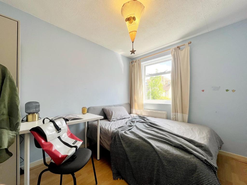 a bedroom with a bed and a desk and a chair at Cozy sunlit room in west London in Yiewsley