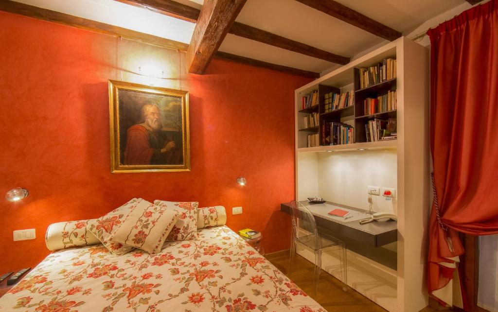 1 dormitorio con 1 cama y escritorio con teléfono en Sitornino Apartment, en Florencia