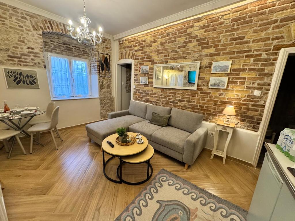 a living room with a couch and a brick wall at Bruskos luxury in Corfu