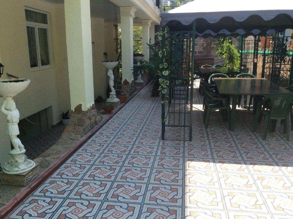 a patio with a tile floor and a table and chairs at Guest House Karina in Sochi