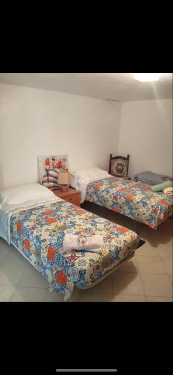 a bedroom with two beds with sheets on them at Cottage Gole Alcantara D’amore in Graniti
