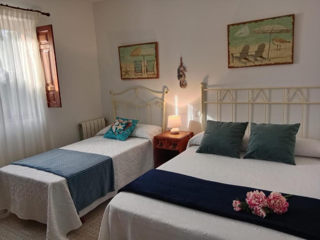a bedroom with two beds and a table with a lamp at Apartamentos Oreña in Oreña
