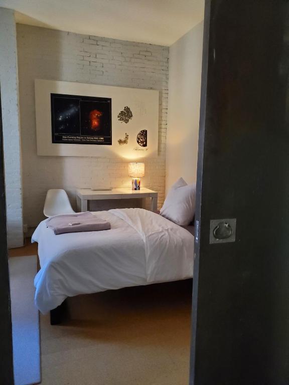 波士顿Beach Street Loft的卧室配有一张床,墙上配有电视。