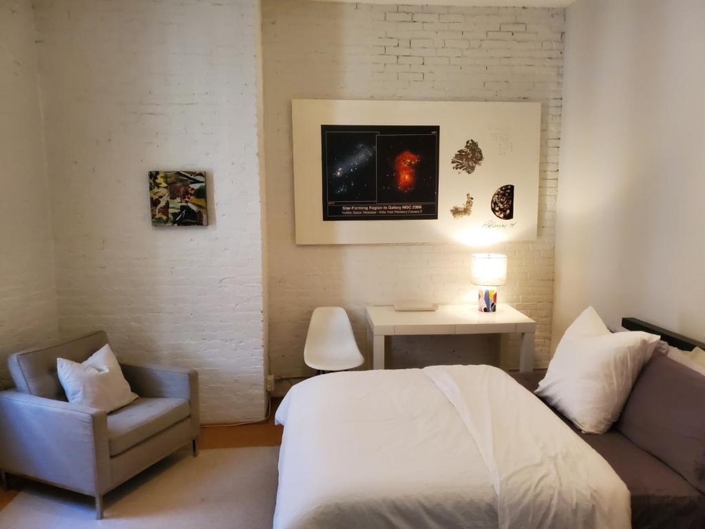 波士顿Beach Street Loft的一间卧室配有一张床、一张沙发和一把椅子